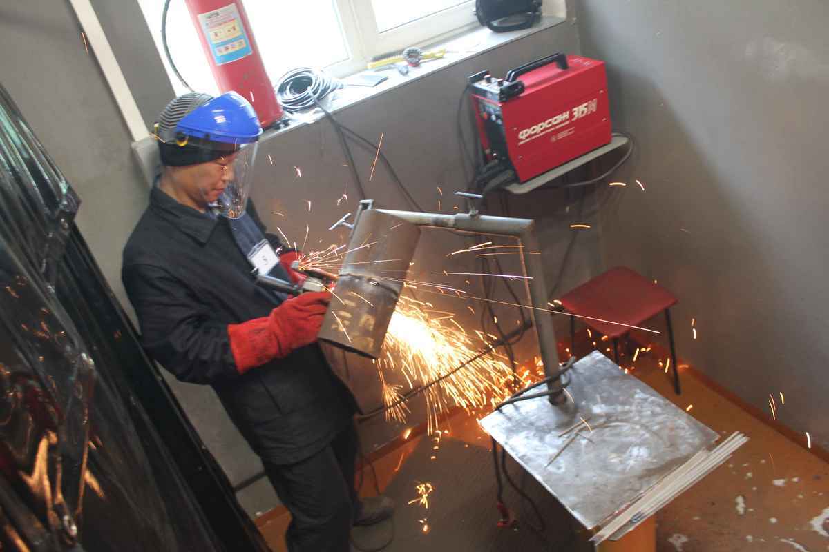 красивый сварщик. сварочная мастерская. лучший сварщик. сварка металлоконструкций полуавтоматом. процесс сварки.