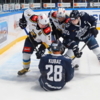 Карел Кубат сидит на льду, а остальные игроки пытаются достать из-под него шайбу — newsvl.ru