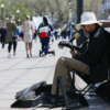 Уличный музыкант прячется в тени от палящего солнца — newsvl.ru