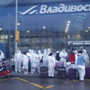 Прилетающие из Москвы во Владивосток китайцы в защитных костюмах удивляют своим видом местных жителей