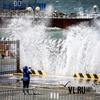 Владивостокцы фотографируются в центре города на фоне больших волн