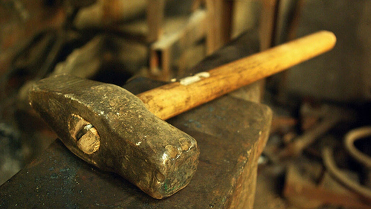 кузнечный горн молот и наковальня. сломанная кувалда. молоток. мужская рука с молотком. молоток горел.